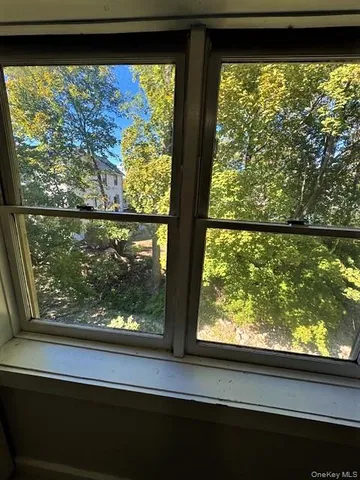 a view of a room with a large window and front door
