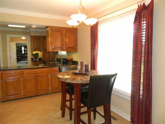 4517 Chandler Road Hermitage, TN 37076 - Photo 12 of 20 Breakfast / Dining Area ... large dining/serving bar divides the Breakfast Area that also features new tile flooring, crown molding, freshly painted, large centered window with wood blinds offers a gorgeous view of the front yard.