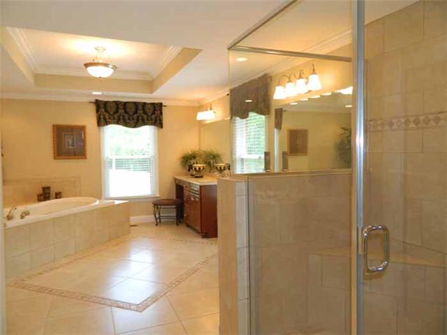 4517 Chandler Road Hermitage, TN 37076 - Photo 4 of 20 master bathroom with heated tile flooring, separate tiled shower, corner jetted tub with tile surrounds, new his & her vanities (w/ knee space), treyed ceiling, all new fixtures & hardware, private water closet, and access to the walk-in closet