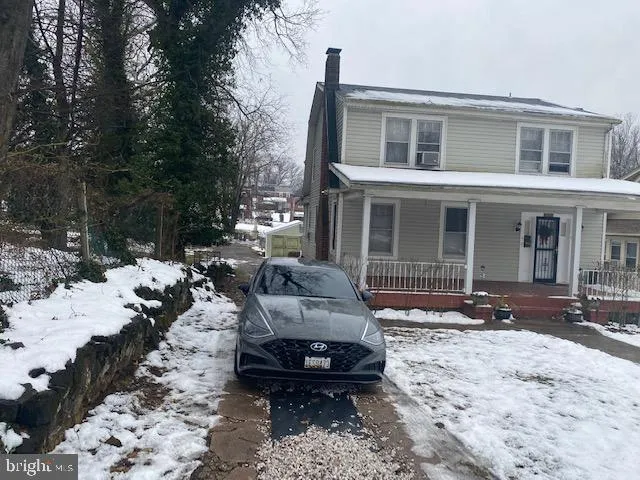 a front view of a house with a yard covered in snow