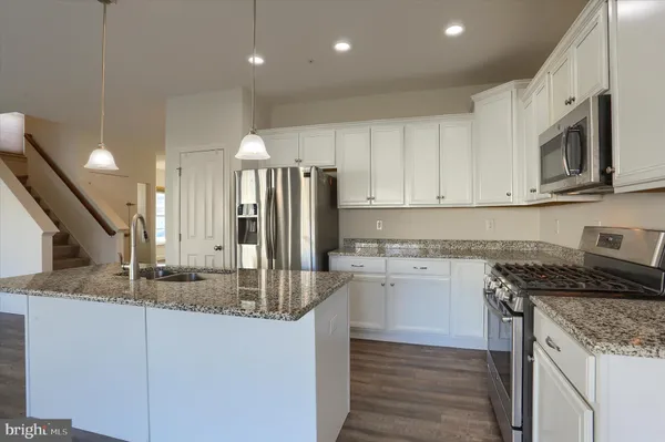 a kitchen with stainless steel appliances granite countertop a sink a stove and a refrigerator