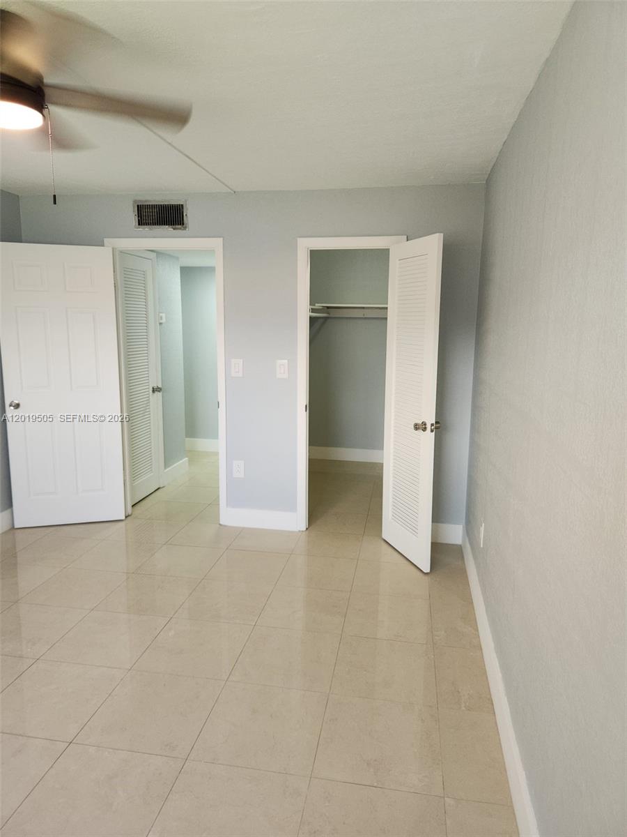 2811 North Pine Island Road, Unit 107 Sunrise, FL 33322 - Photo 11 of 16 an empty room with closet and mirrors