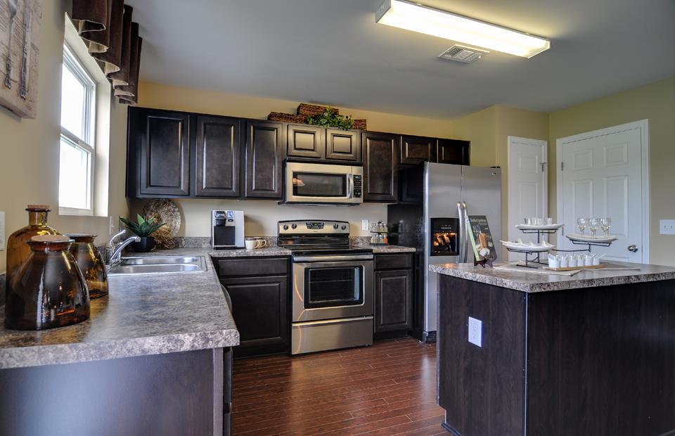 1433 Old Stone Road, Unit 697 Lebanon, TN 37087 - Photo 7 of 20 a kitchen with kitchen island granite countertop a stove sink and cabinets