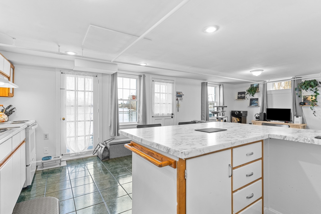 327 Bridle Path Worcester, MA 01604 - Photo 23 of 40 a hall with kitchen island a stove a sink and a granite counter tops with white cabinets