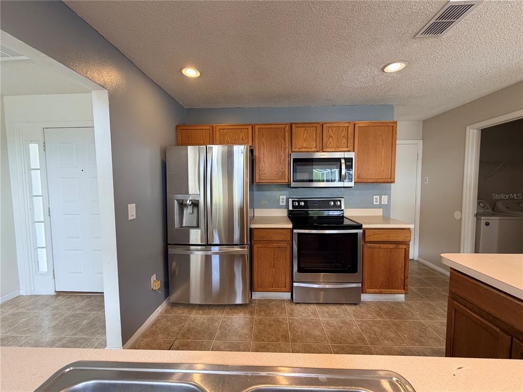 1214 Timberbend Circle Orlando, FL 32824 - Photo 12 of 31 a kitchen with a refrigerator and a stove top oven