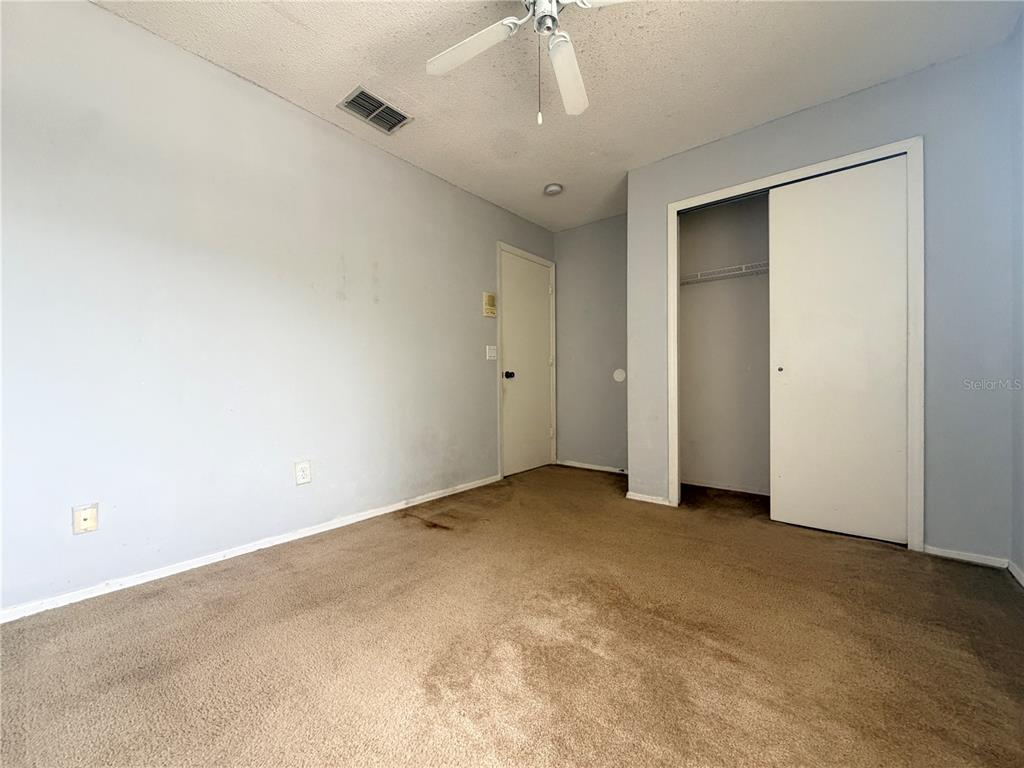 1214 Timberbend Circle Orlando, FL 32824 - Photo 15 of 31 an empty room with a ceiling fan and closet area