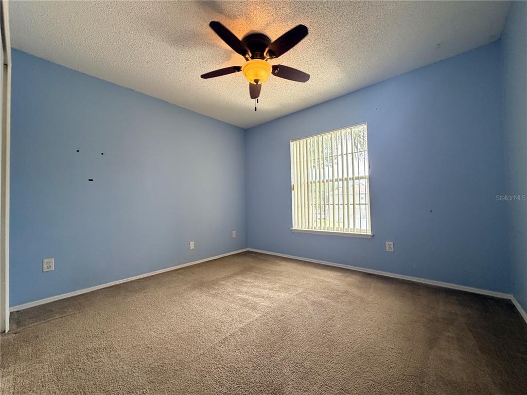 1214 Timberbend Circle Orlando, FL 32824 - Photo 18 of 31 an empty room with windows and chandelier fan