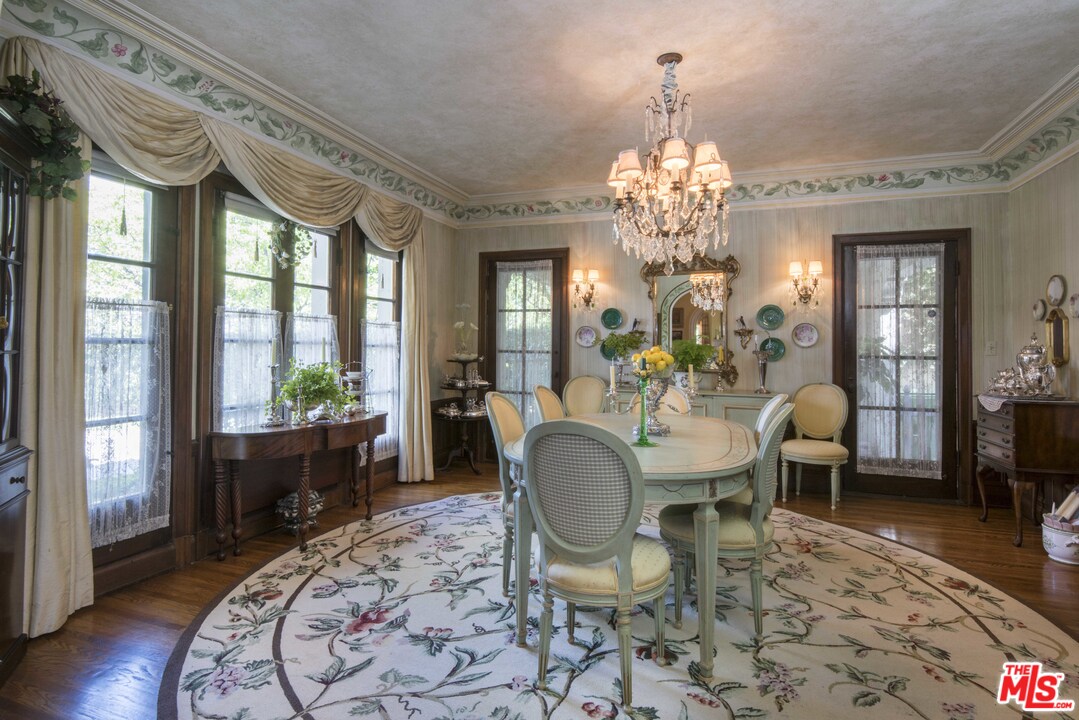508 South Rimpau Boulevard Los Angeles, CA 90020 - Photo 20 of 48 a dining room with wooden floor a chandelier a wooden table and chairs