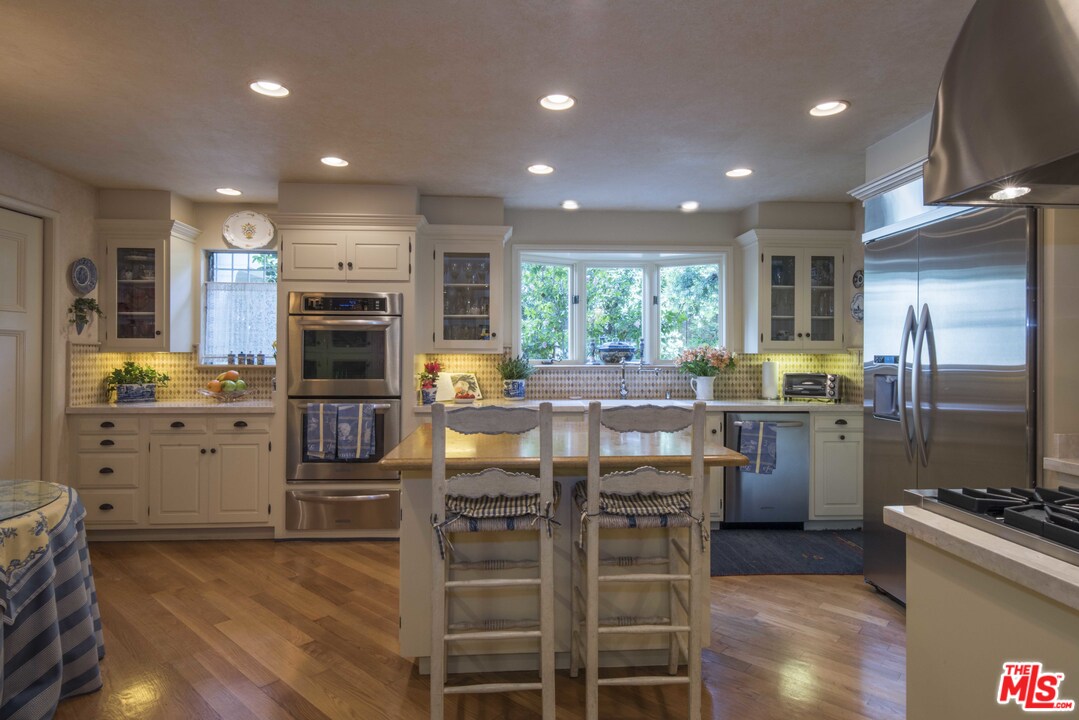 508 South Rimpau Boulevard Los Angeles, CA 90020 - Photo 23 of 48 a kitchen with refrigerator a stove and chairs