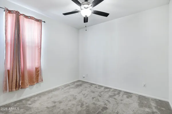 an empty room with closet and windows