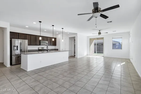 a view of kitchen with stainless steel appliances kitchen island granite countertop a refrigerator and a stove top oven