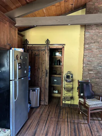 a kitchen with a refrigerator and a wooden floor