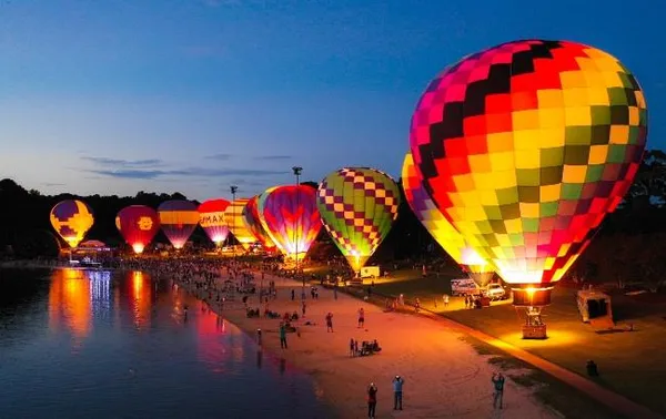 a view of a lake with a table and chairs under an umbrella