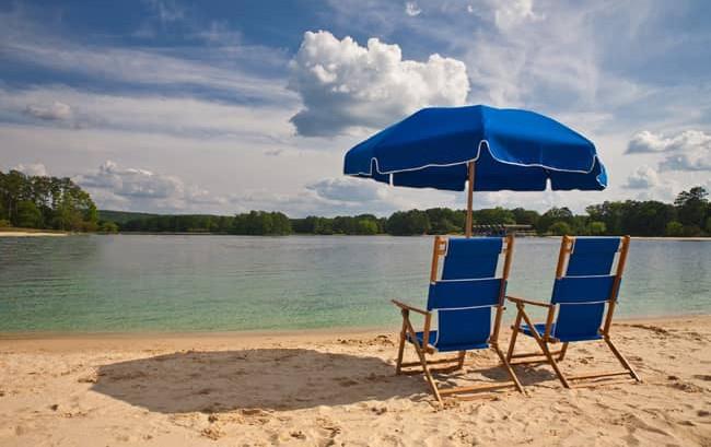 279 White Oak Road Pine Mountain, GA 31822 - Photo 22 of 25 a view of a lake with a table and chairs under an umbrella