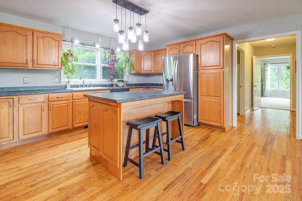 908 Newfound Road Leicester, NC 28748 - Photo 15 of 46 a kitchen with stainless steel appliances granite countertop a kitchen island hardwood floor sink stove dining table and chairs
