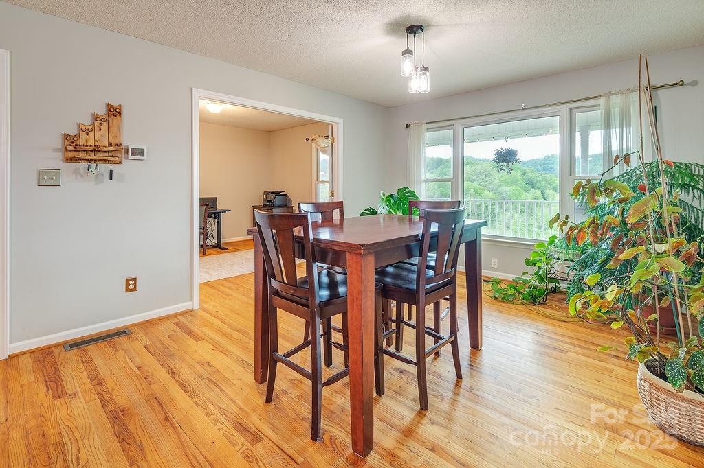 908 Newfound Road Leicester, NC 28748 - Photo 21 of 46 a view of a dining room with furniture window and wooden floor
