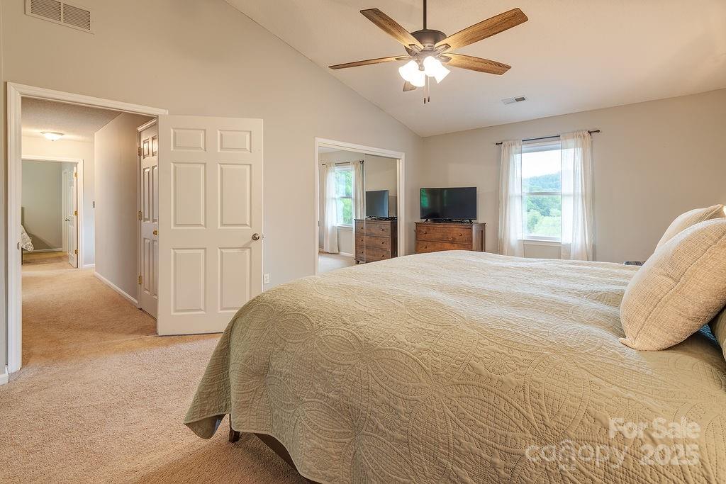 908 Newfound Road Leicester, NC 28748 - Photo 29 of 46 a spacious bedroom with a large bed and a chandelier