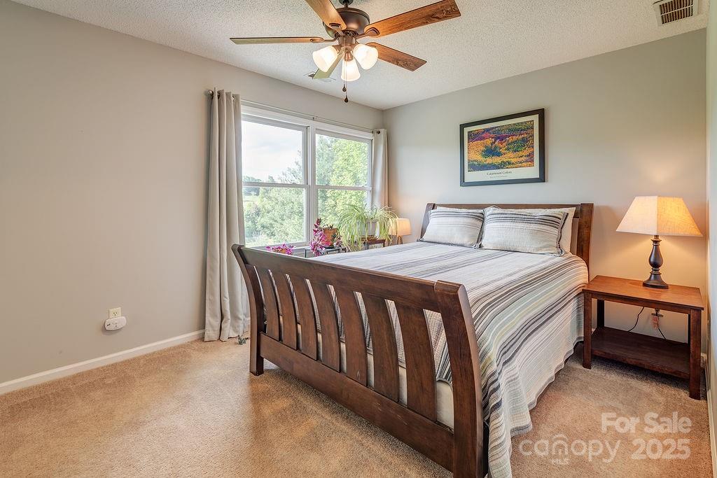 908 Newfound Road Leicester, NC 28748 - Photo 36 of 46 a bedroom with a bed and a chandelier