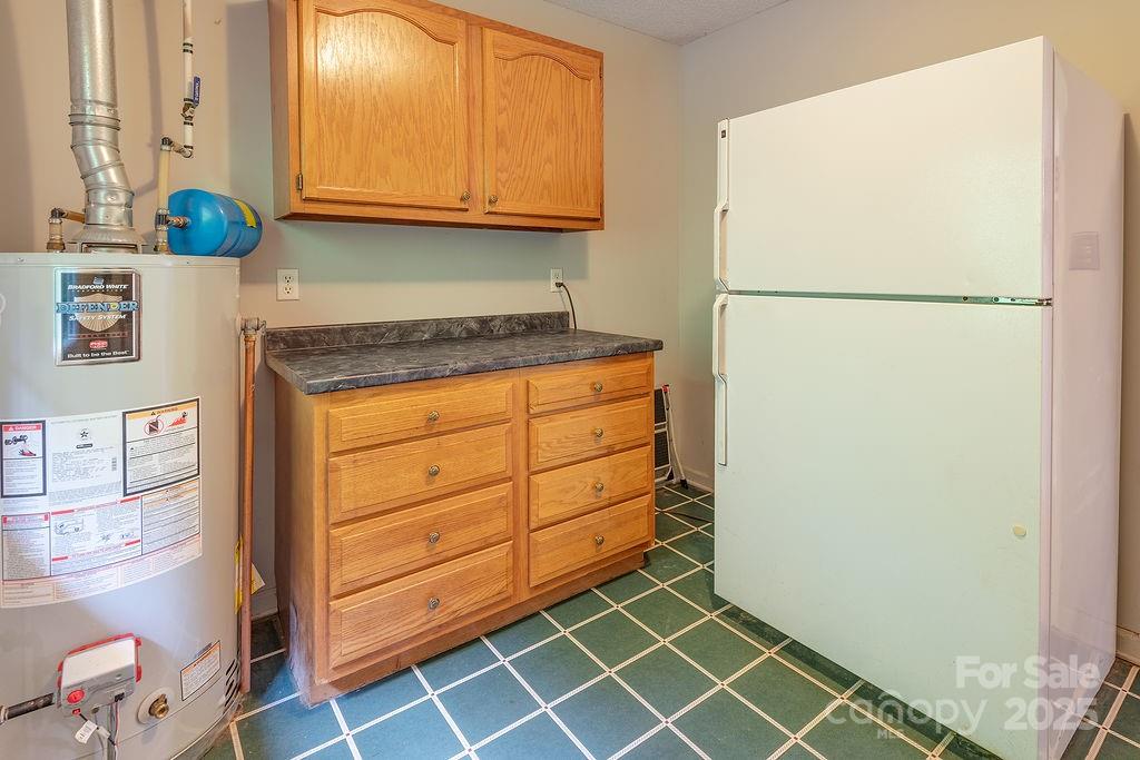 908 Newfound Road Leicester, NC 28748 - Photo 38 of 46 a kitchen with granite countertop a refrigerator and a sink