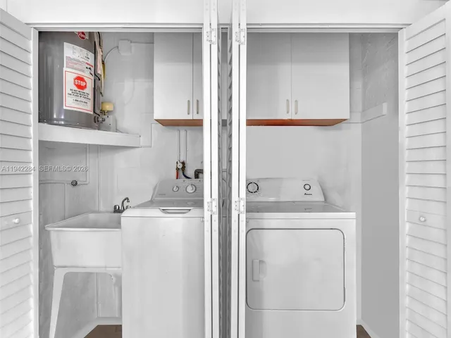 a utility room with dryer washer and a view of kitchen