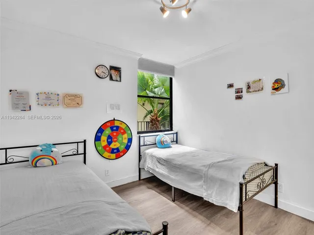 a bedroom with a bed a wall painting and a window