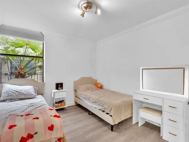 a bedroom with two beds and large window