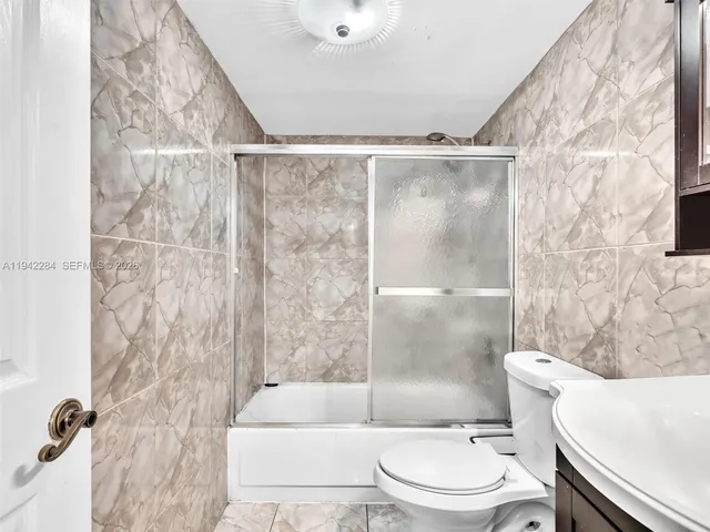 a white toilet sitting next to a bath tub