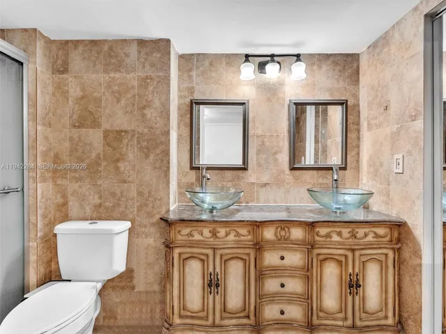 a bathroom with a granite countertop toilet sink and mirror