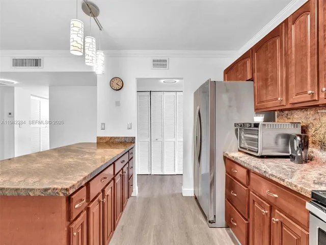 a kitchen that has a lot of counter space and wooden floor