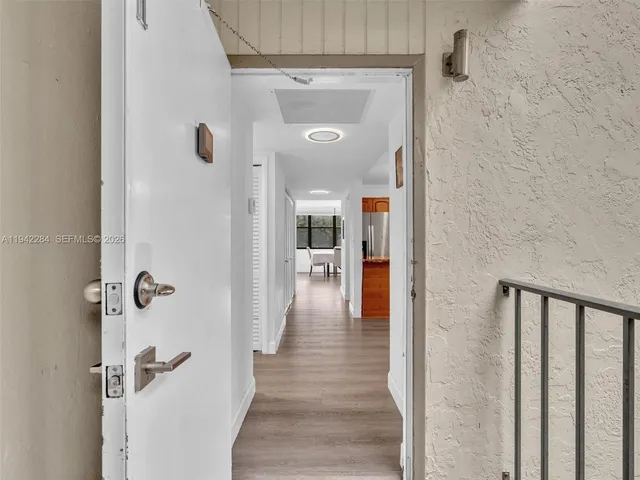 a view of a hallway with wooden floor and staircase