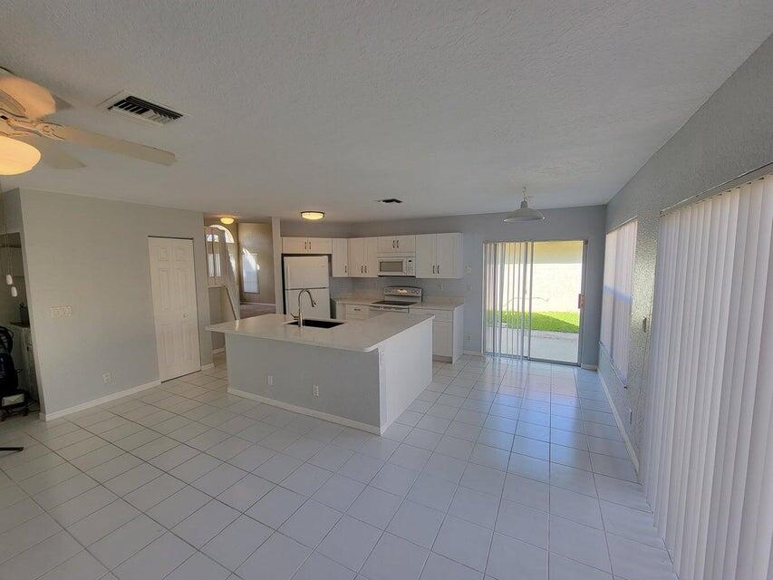 23344 Sunview Way Boca Raton, FL 33428 - Photo 18 of 23 a large white kitchen with a sink a window and stainless steel appliances