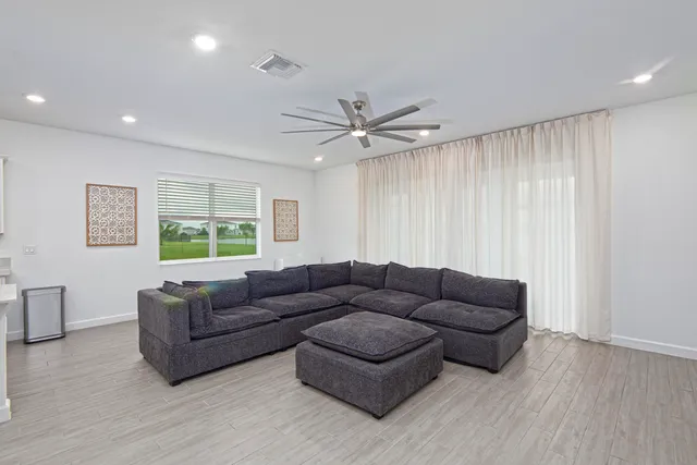 a kitchen with stainless steel appliances kitchen island granite countertop a table chairs stove and white cabinets