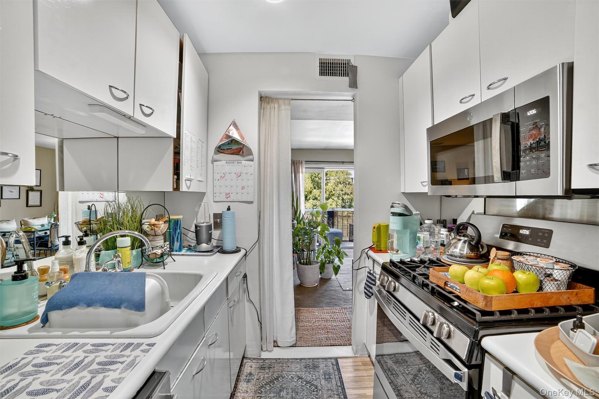 37 Harbor Lane, Unit 2A New Rochelle, NY 10805 - Photo 13 of 23 a kitchen with a stove a sink and a microwave