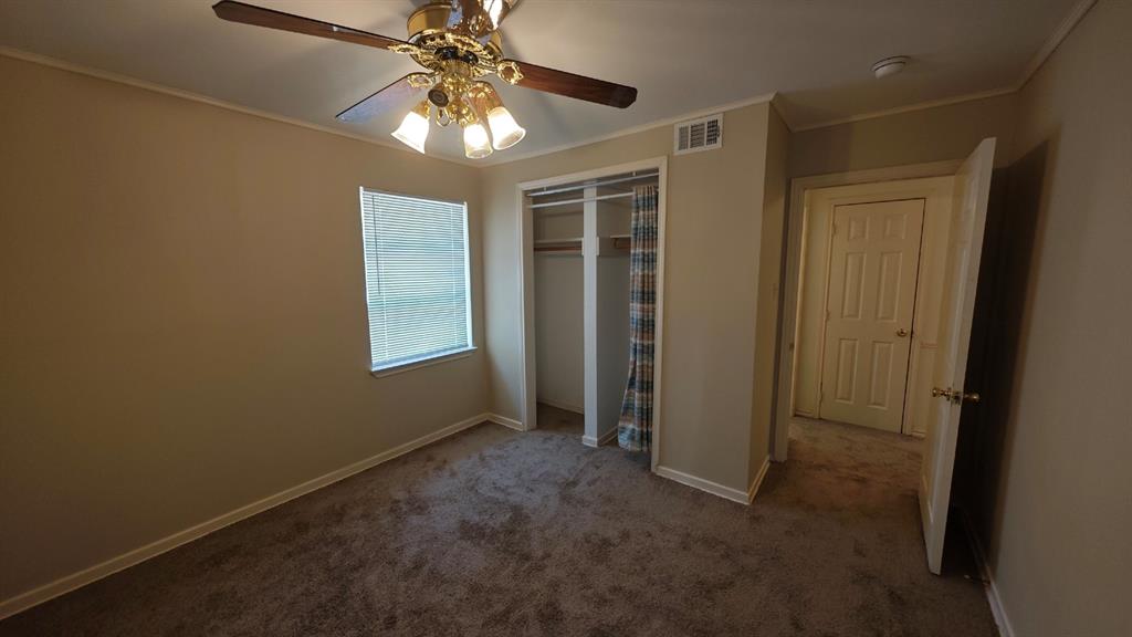 12225 Schroeder Road Dallas, TX 75243 - Photo 36 of 40 Carpeted room with a ceiling fan light fixture, window with blinds, and a built-in closet with curtain