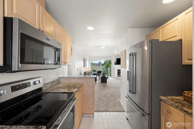 a kitchen with stainless steel appliances granite countertop a refrigerator stove and sink