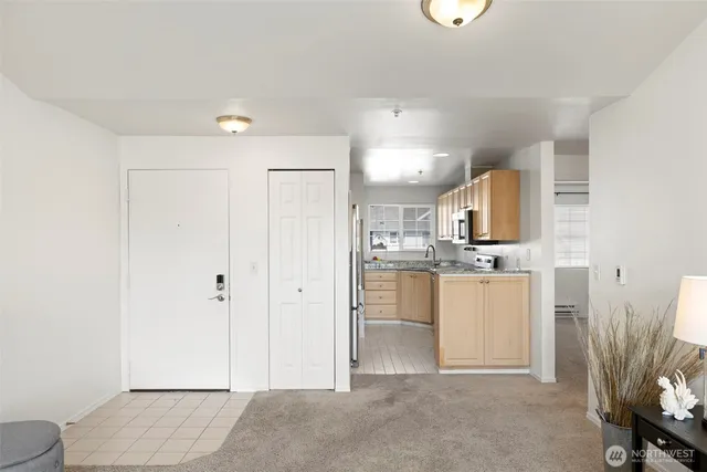 a view of a kitchen with refrigerator and white cabinets