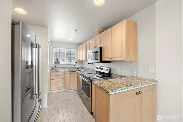 a kitchen with a refrigerator stove top oven and sink