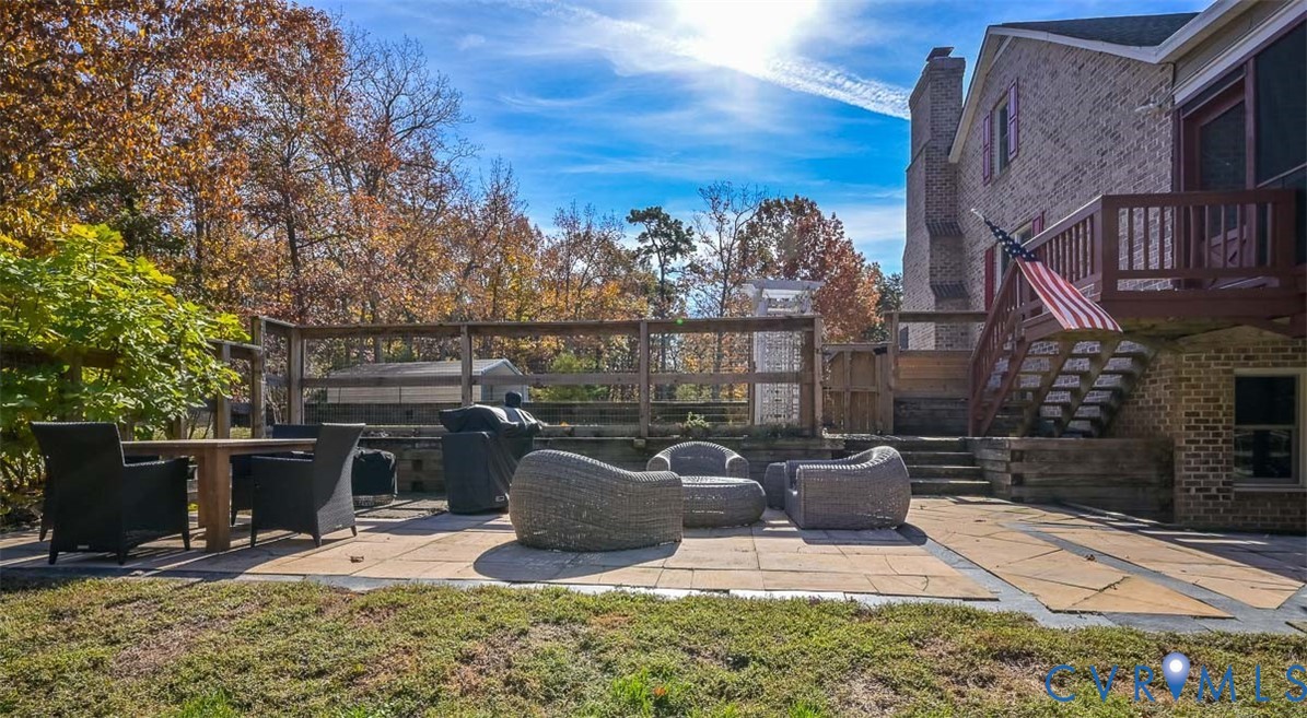 425 Starview Lane Gum Spring, VA 23065 - Photo 41 of 50 a view of a patio with table and chairs potted plants and wooden fence