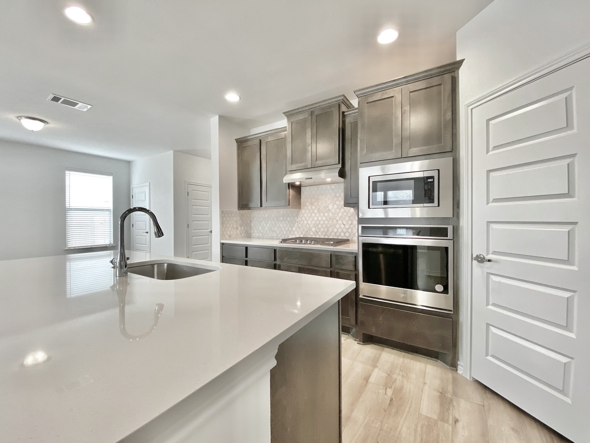 1852 Turtle Bay Loop Leander, TX 78641 - Photo 11 of 38 a kitchen with stainless steel appliances and white cabinets