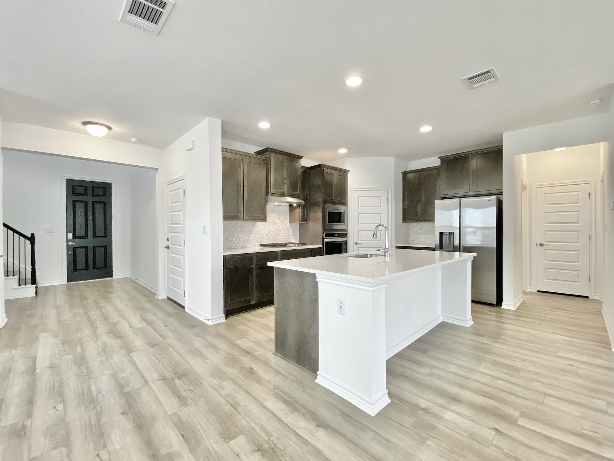 1852 Turtle Bay Loop Leander, TX 78641 - Photo 4 of 38 a large kitchen with stainless steel appliances a large counter top a stove and a refrigerator