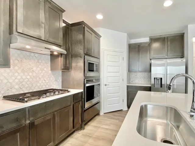 a kitchen with granite countertop a sink stainless steel appliances and cabinets