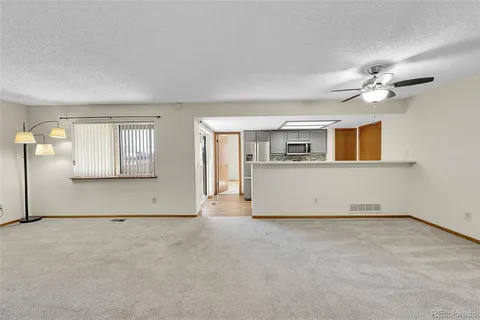 an empty room with windows and ceiling fan