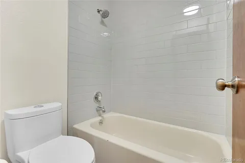 a white toilet sitting next to a bathtub