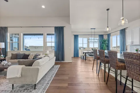 a living room with furniture dining table and a large window