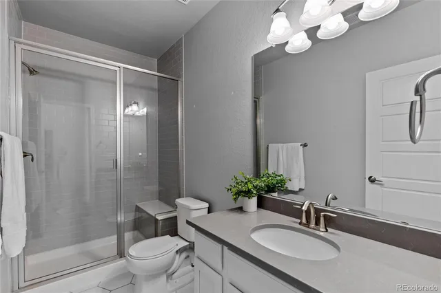 a bathroom with a granite countertop sink a toilet and a mirror