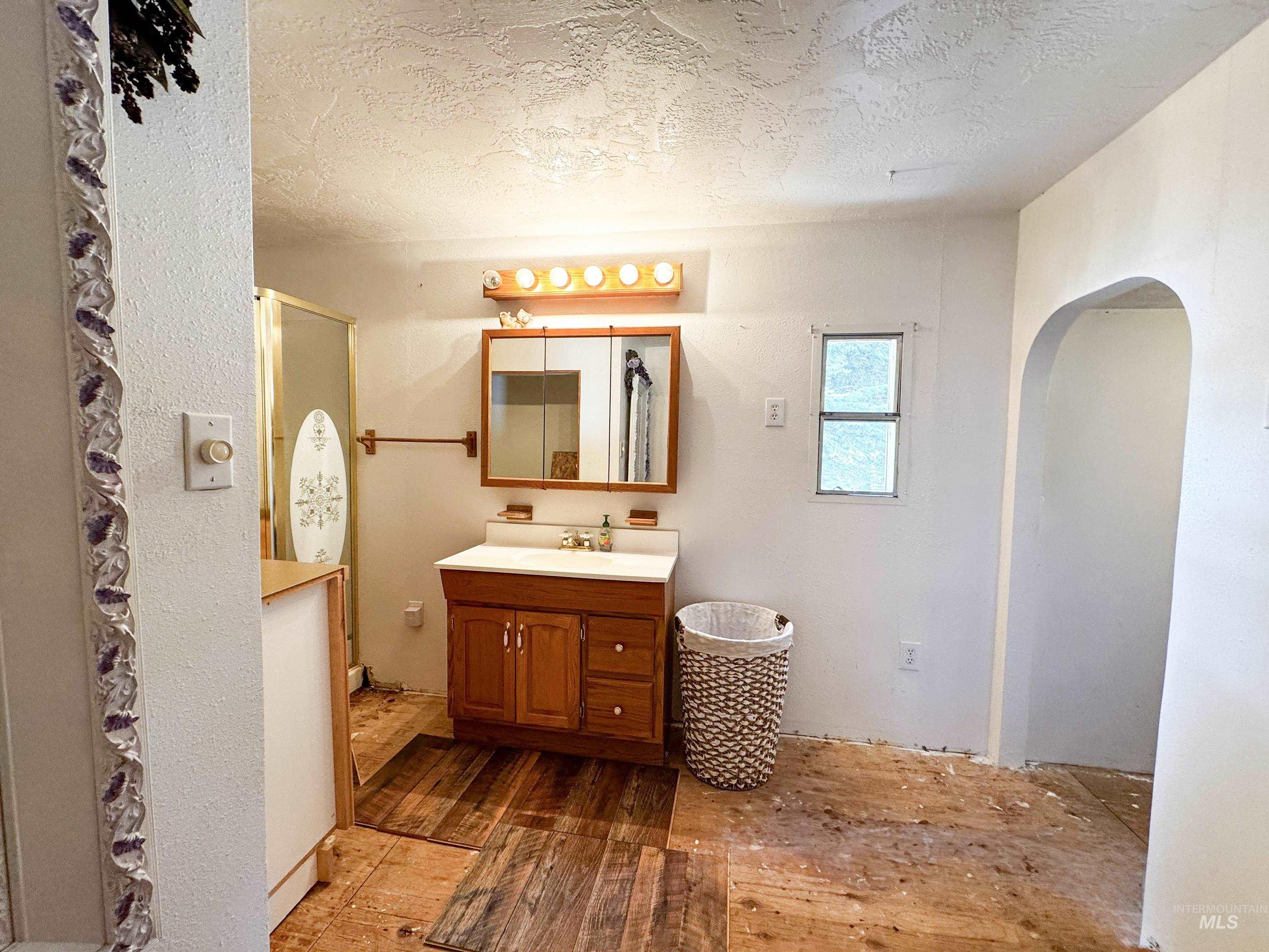 4482 Council Cuprum Road Council, ID 83612 - Photo 12 of 45 Bathroom with a textured ceiling, hardwood / wood-style floors, vanity, and a stall shower