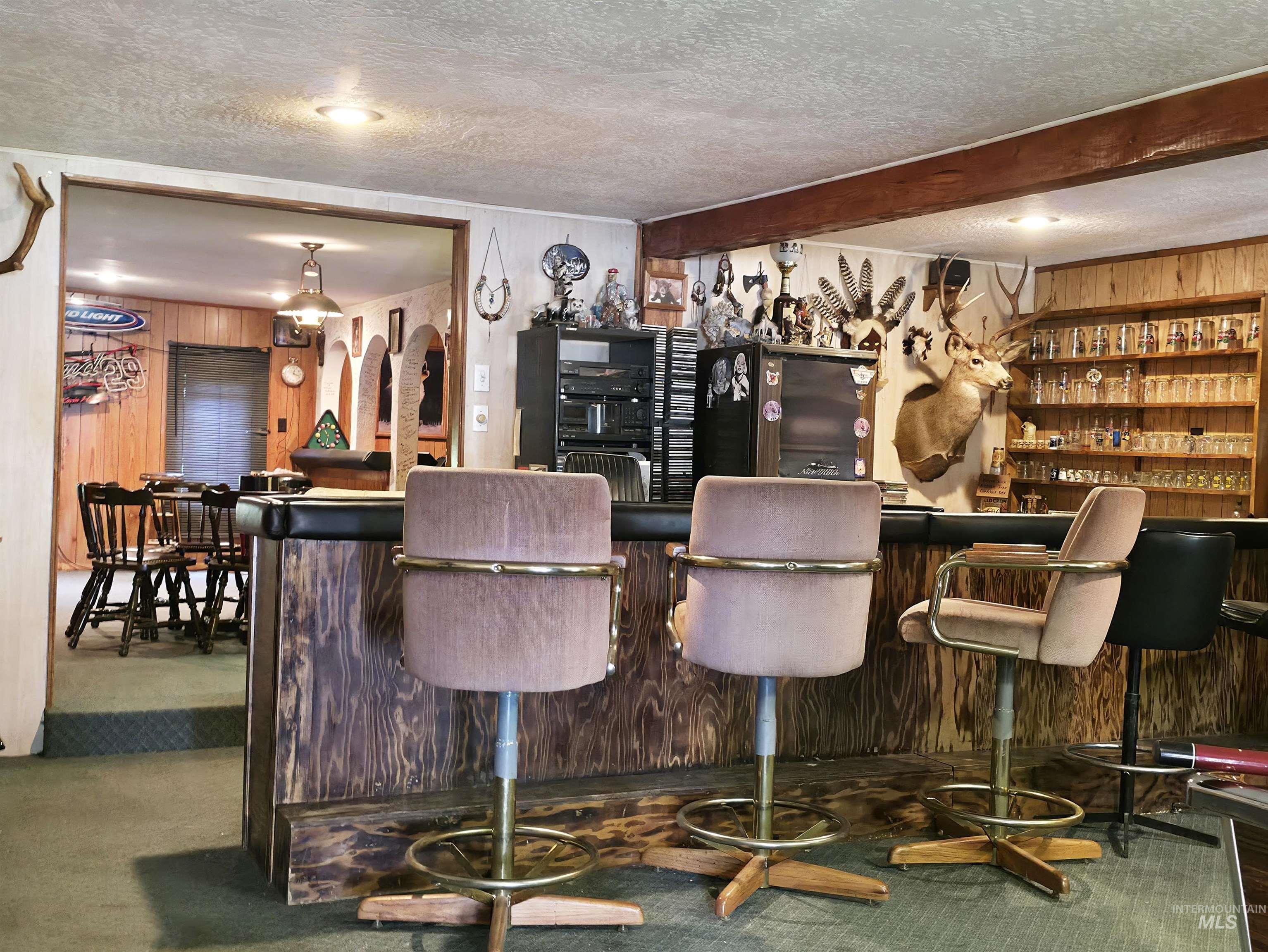 4482 Council Cuprum Road Council, ID 83612 - Photo 24 of 45 Indoor dry bar featuring wood walls and a textured ceiling