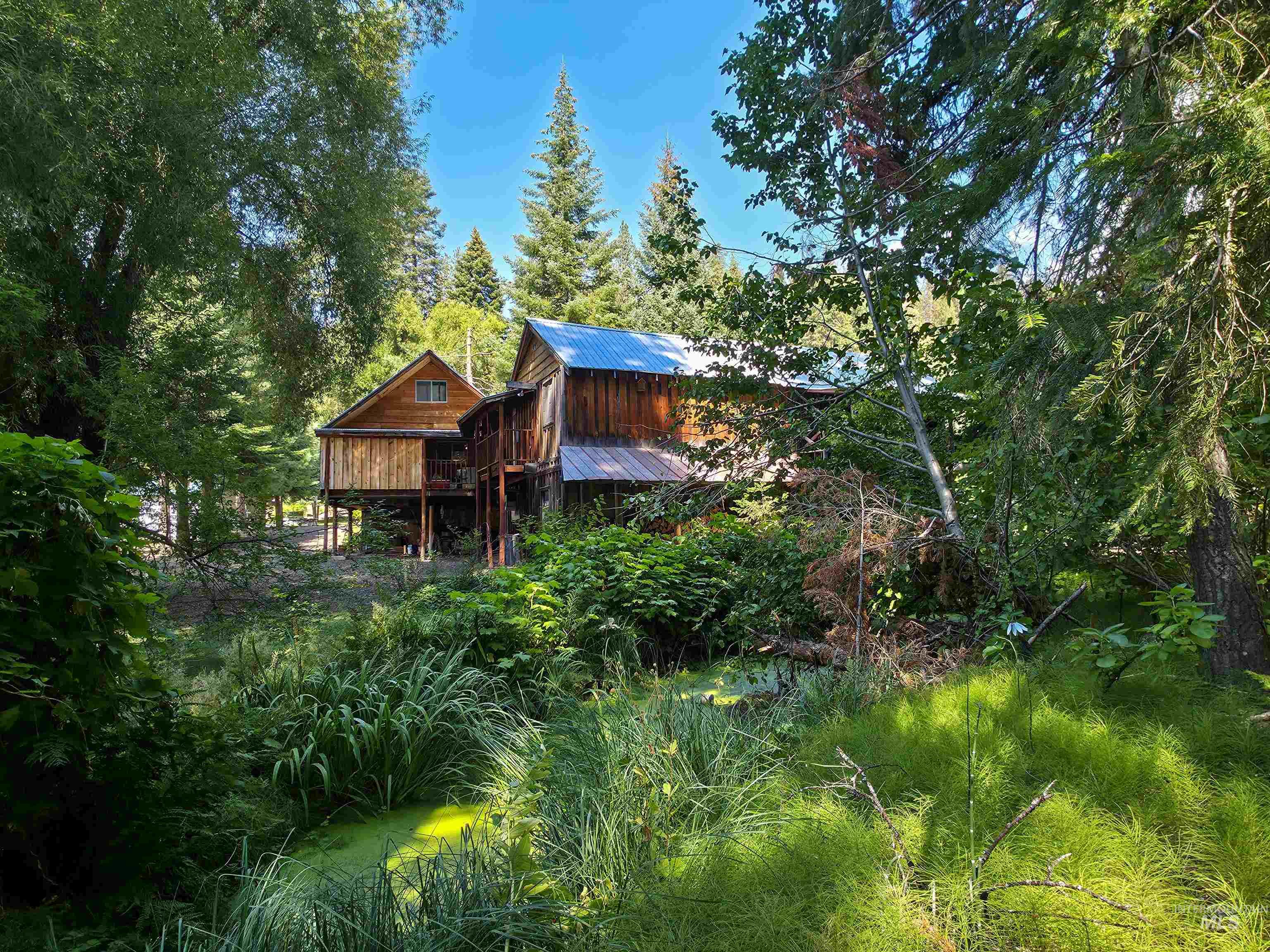 4482 Council Cuprum Road Council, ID 83612 - Photo 33 of 45 Rear view of house with a wooden deck, a metal roof, and a wooded view