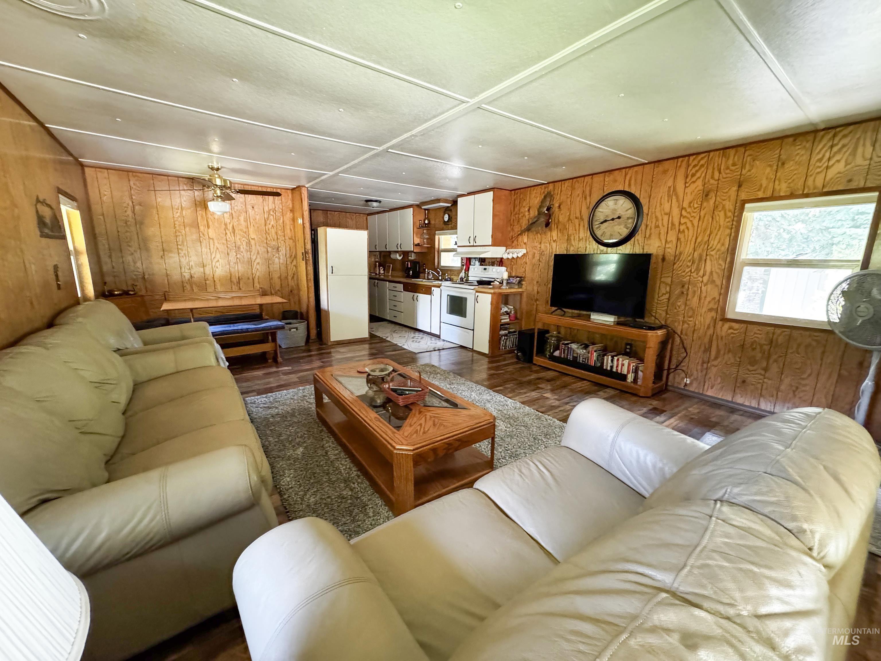 4482 Council Cuprum Road Council, ID 83612 - Photo 8 of 45 Living area with wooden walls, wood finished floors, and a ceiling fan