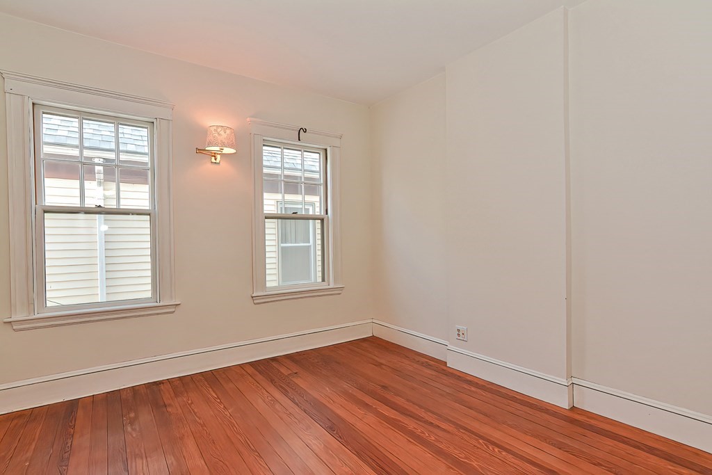 17-19 Walnut Road Somerville, MA 02145 - Photo 18 of 42 an empty room with wooden floor and windows